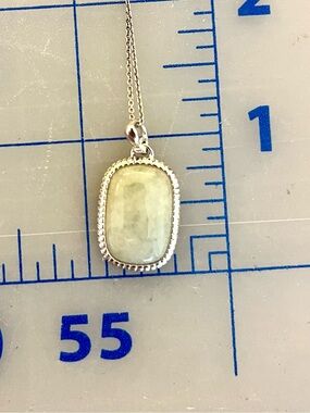 Pale greenish grey pendant in silver-coloured setting with chain